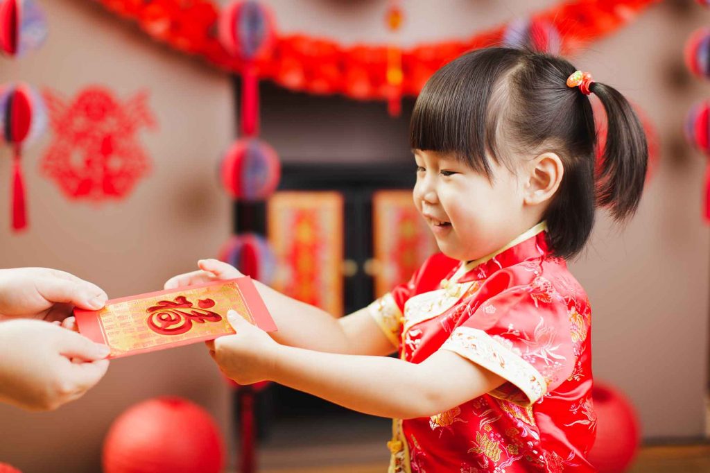 Chinese toddler girl  traditional dressing up with a "FU"means "lucky" red envelope